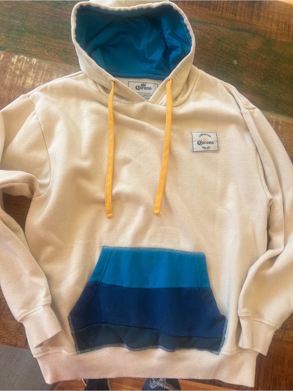 Corona Cream Hoodie with Blue Pocket and Yellow Drawstrings size medium